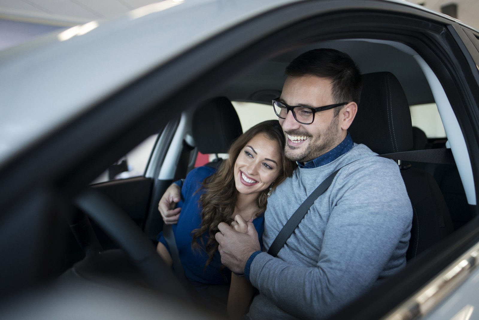 Insurance Blog ,Happy young couple enjoying their brand new car.